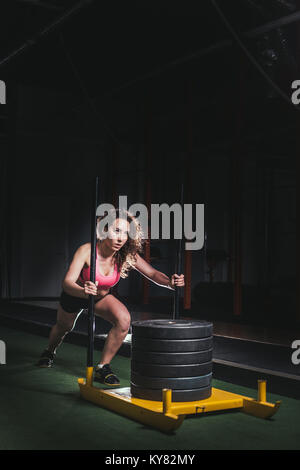 sled push woman pushing weights workout exercise Stock Photo