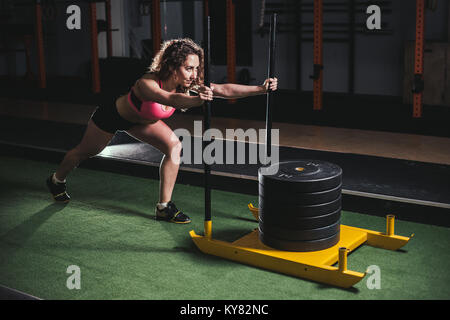 sled push woman pushing weights workout exercise Stock Photo
