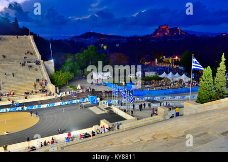 Night inside the Panathenaic Stadium at end of sporting event with view to Parthenon and city skyline Stock Photo