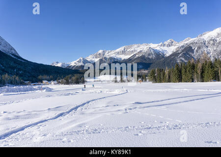 Winter mountains landscape with groomed ski track and blue sky in sunny day Stock Photo