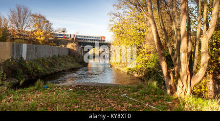 London, England, UK - November 18, 2012: A South West Trains Class 444 passenger train crosses the River Wandle on the South West Main Line railway in Stock Photo