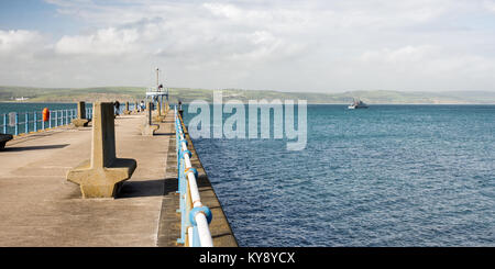 UK Border Agency customs cutter HMC Valiant passes the Stone Pier leaving Weymouth Harbour in Dorset. Stock Photo