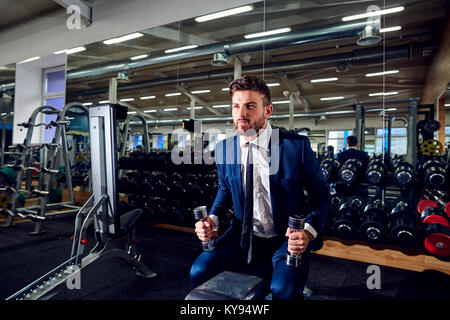 Businessman doing exercises with dumbbells . Stock Photo