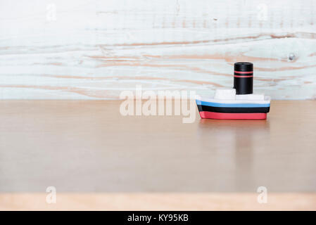 small, vintage, antique wood toy boat shot against neutral background Stock Photo