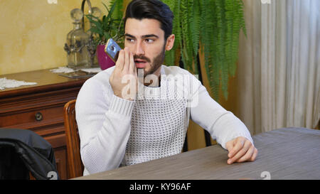 Young man sending voice message with cell phone Stock Photo