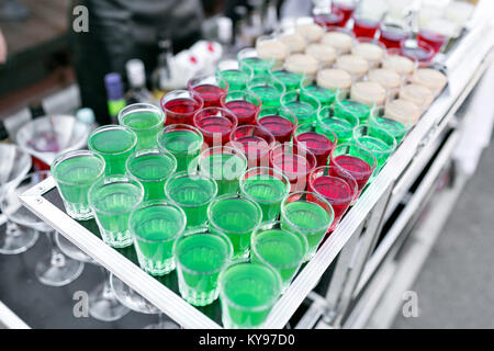 row line of different colored alcoholic cocktails on a party. wedding day or birthday Stock Photo