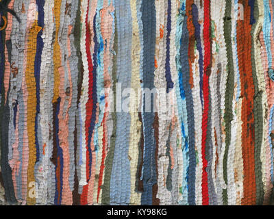 Bright colored background of strips of homespun rug, stripes alternating red, blue, blue, white and black. Stock Photo