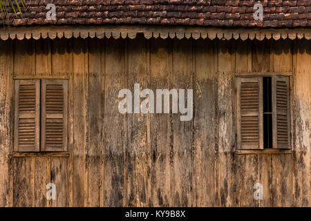 Paired Beautiful old slatted window shutters on a traditional Cambodian wooden house. Stock Photo