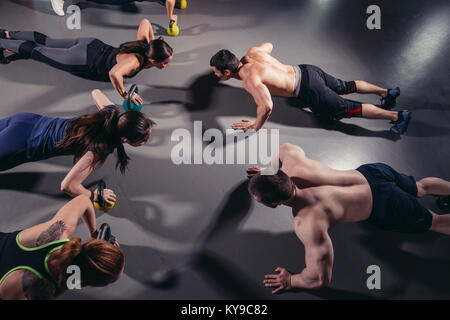 Group adults doing push up exercises indoor Stock Photo