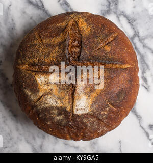 Homemade Easter traditional sourdough bread with cross sign cut. Stock Photo