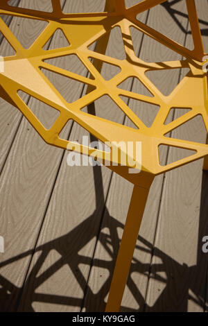 looking down at patterns in a yellow chair and shadows cast Stock Photo
