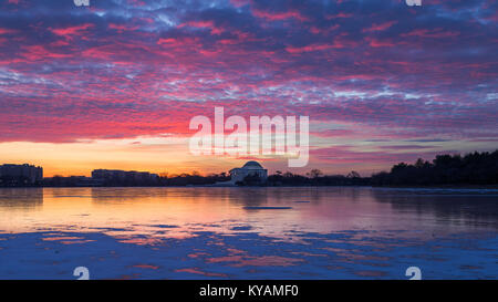 Colors are cast in the sky at sunrise over a frozen Tidal Basin and Jefferson Memorial in Washington, D.C. Stock Photo