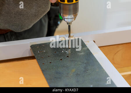 Bearded man with a screwdriver in his hands is screwed with self-tapping sheets of metal profile, selective focus master drill a metal Stock Photo