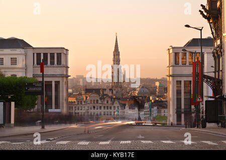 View from Place Royale to Grand Place with the tall tower of the Hotel De Ville. Long exposure shot with warm evening light. Stock Photo