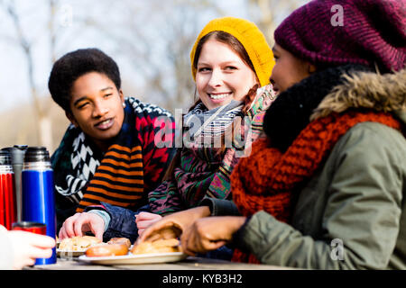 Young friends talking at picnic outdoors in the park Stock Photo
