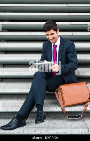 Businessman using a tablet for communication or data storage out Stock Photo