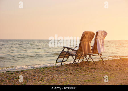 Deck chairs with towels on backrest on the seashore. Stock Photo