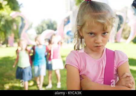 Sad lonely child being bullied by children Stock Photo