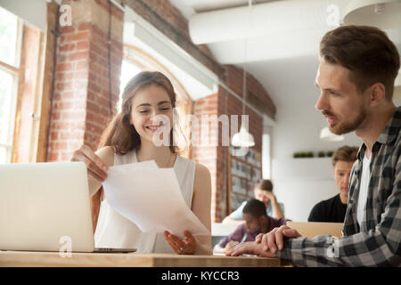 Businesswoman discussing business documents at meeting with client customer in shared office, smiling woman employee helping mentoring young man inter Stock Photo