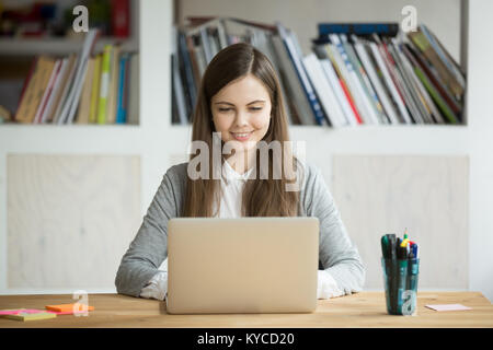Smiling girl using laptop, student studying at home, digital education, teenager typing on computer browsing web, blogger influencer chatting online i Stock Photo