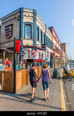 Couple holding hands walking on downtown street in Victoria Canada Stock Photo