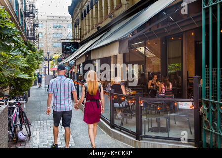 Couple holding hands walking on downtown street in Victoria Canada Stock Photo