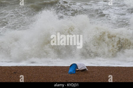 Brighton, UK. 15th Jan, 2018. A tent is precariously pitched on Brighton beach this morning as waves crash in during gales and heavy rain along the south coast with colder weather forecast to hit Britain later in the week Credit: Simon Dack/Alamy Live News Stock Photo