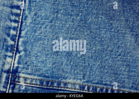 Textured vintage background - blue jeans textile denim with seam of fashion design in close-up (high details). Stock Photo