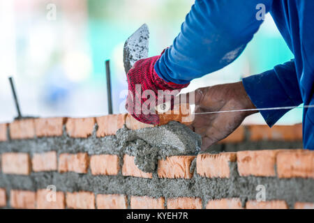 construction worker laying bricks and building in construction site Stock Photo