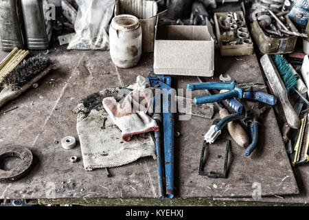 uncleared workshop with tools. on the dirty stone table scattered tools Stock Photo