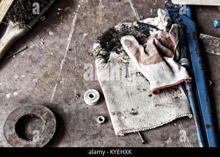 uncleared workshop with tools. on the dirty stone table scattered tools Stock Photo