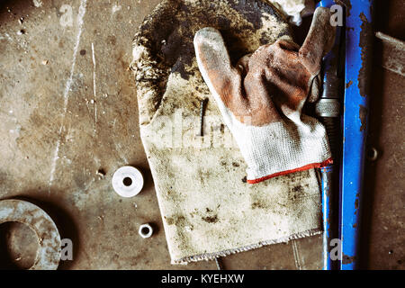 uncleared workshop with tools. on the dirty stone floor scattered tools Stock Photo
