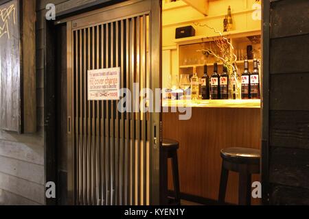 View into a brightly lit bat at night in the Golden Gai neighborhood of Shinjuku, Tokyo, Japan, an area known for its vibrant night life and bar scene, October 24, 2017. () Stock Photo