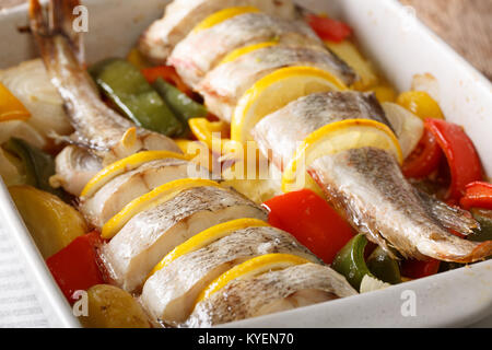 Atlantic cod baked with vegetables in a baking dish close up on a table. horizontal Stock Photo