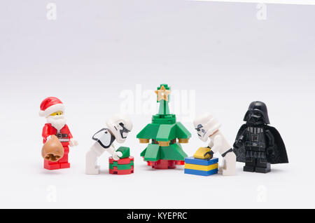 lego santa claus and darth vader watching storm trooper decorate christmas tree. Stock Photo