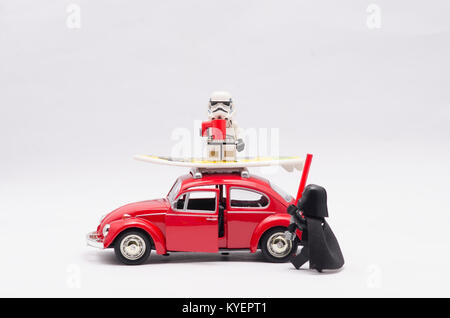 lego darth vader watching storm trooper drink while sitting on volkswagen roof. Stock Photo