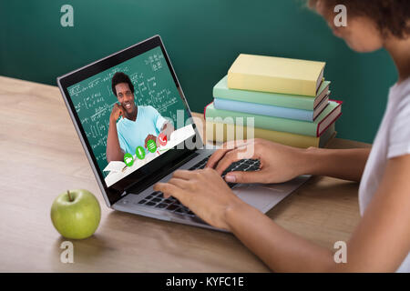 Close-up Of Female Student Video Conferencing With Smiling Male Teacher On Laptop Stock Photo