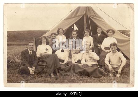 Early1900s postcard of a group of men and women camping under canvas, relaxing and enjoying themselves outside a canvas tent, probably just before the Great War, circa 1913, U.K Stock Photo