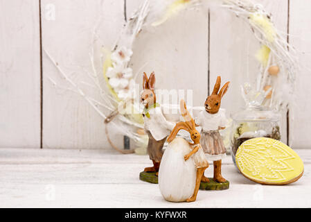 Happy Easter decoration for greeting card. Easter bunny, wreath, gingerbread Easter cookies in shape of Easter eggs on white background. Vintage style Stock Photo