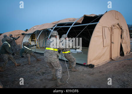 Airmen from the Kentucky Air National Guard’s 123rd Contingency Response Group set up an Alaskan Shelter tent at Joint Base McGuire-Dix-Lakehurst, N.J., March 26, 2012, during Exercise Eagle Flag. More than 80 Airmen from the Kentucky Air Guard have joined forces with over 50 active-duty Army troops and Air Guardsmen from New Jersey and Mississippi to establish an aerial port at Lakehurst Naval Air Engineering Station within 24 hours of arrival. Inspectors from U.S. Transportation Command will evaluate the performance of the Kentucky unit during the exercise. (U.S. Air Force photo by Maj. Dale Stock Photo