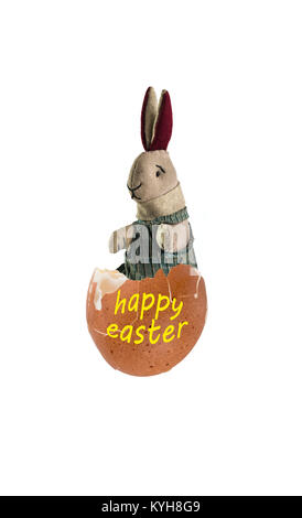 Soft toy rabbit sitting inside an egg shell, with the words happy easter. Stock Photo
