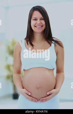 woman holds her baby bump. Stock Photo