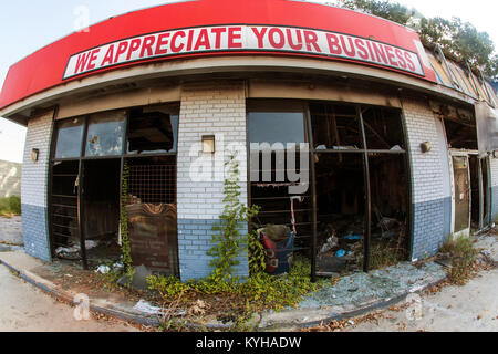 Atlanta, GA, USA - September 23, 2017:  Fisheye view of a sign reading 'We appreciate your business' sits above a vandalized, burned out business. Stock Photo