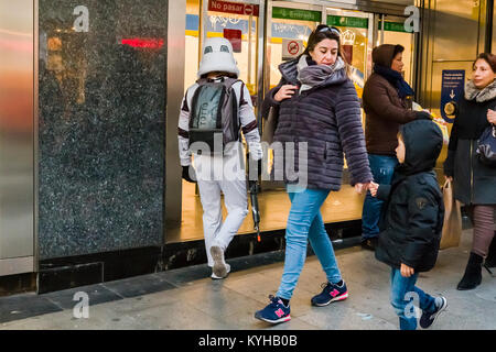 A young boy looking at a street performer dressed as storm trooper entering the Metro in Madrid Stock Photo