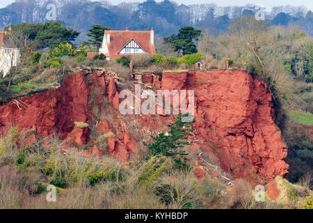 Red Permian breccia rockfall on the cliffs at Oddicombe beach, Babbacombe,Torquay, Devon. Wreckage from a destroyed house litter the slope. Stock Photo