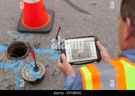 Water department technician reading a flow sensor Stock Photo