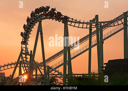 Isla Magica (Magic Island) Theme Park, The Jaguar at sunset - roller coaster (and people upside), Seville, Region of Andalusia, Spain, Europe Stock Photo