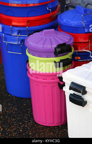 Coloured plastic bins pictured outside an independent discount store in East Wittering, West Sussex, UK. Stock Photo