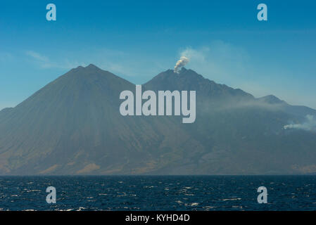 A view of the volcano peaks and a small eruption of the active volcano Sangeang Api (Gunung Api) off the northeast of Sumbawa, Indonesia. Stock Photo