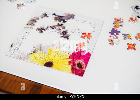 A jigsaw puzzle with work in progress on a white artboard. USA. Stock Photo